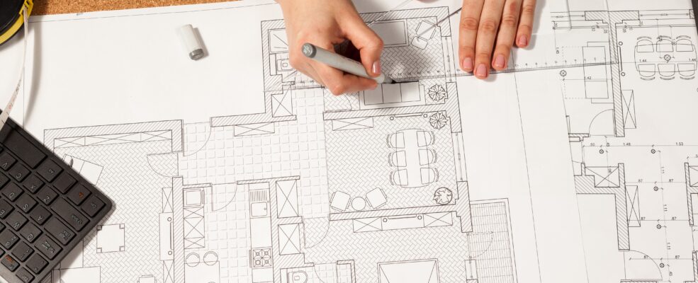 Close up shot of an architect working on the blueprint of a private residence to illustrate that there is work beyond public tenders
