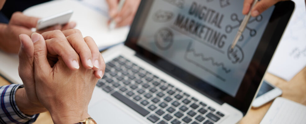 People at a business meeting going over a digital marketing plan on a laptop